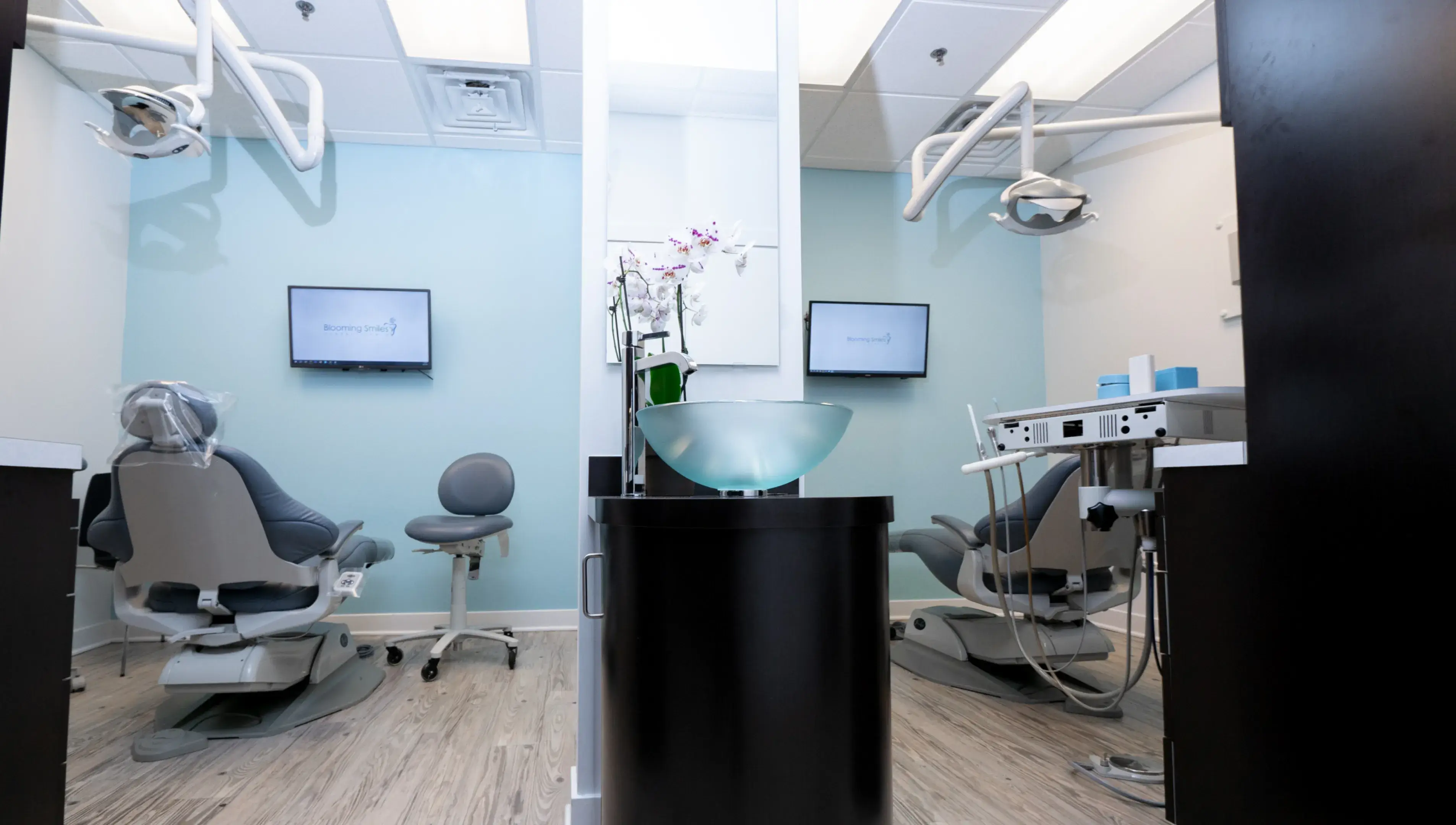 a dentist's office with chairs and monitors